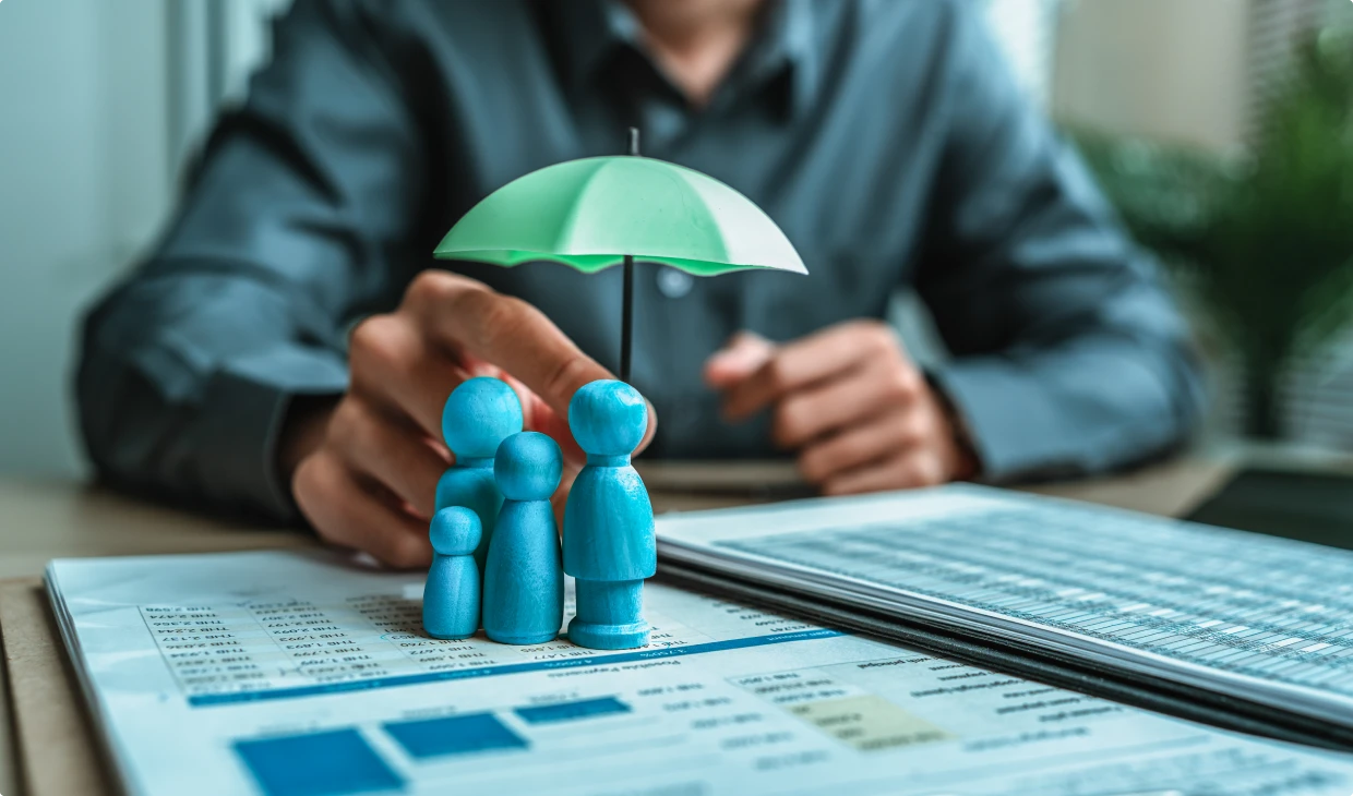 Hand holding umbrella over small family figures