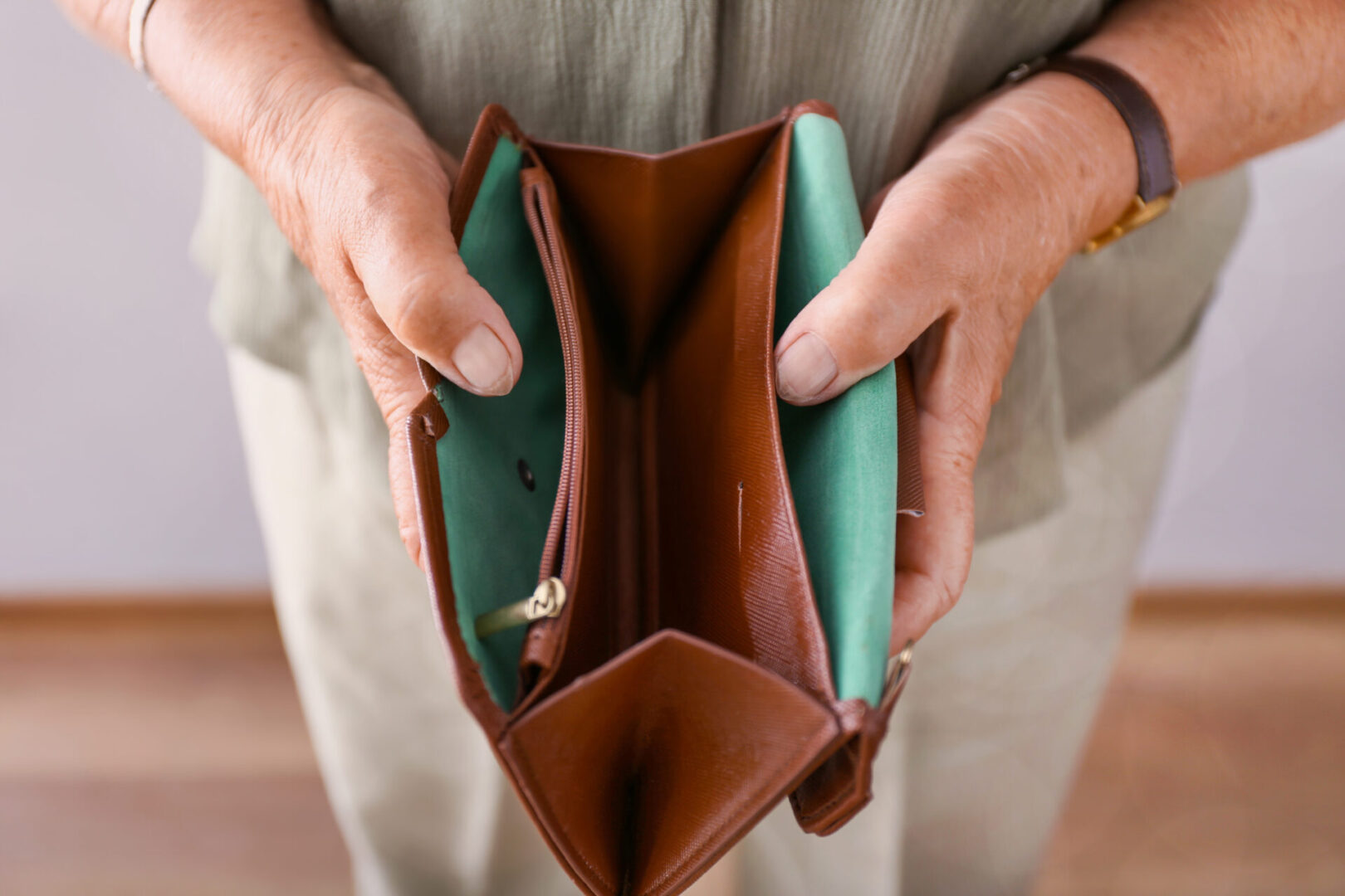 Elderly woman with empty wallet, closeup. Concept of poverty in retirement