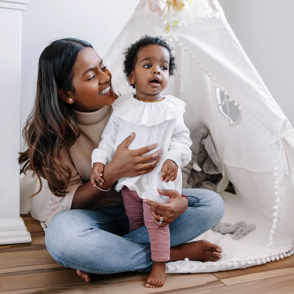 Mother holding her young child at home